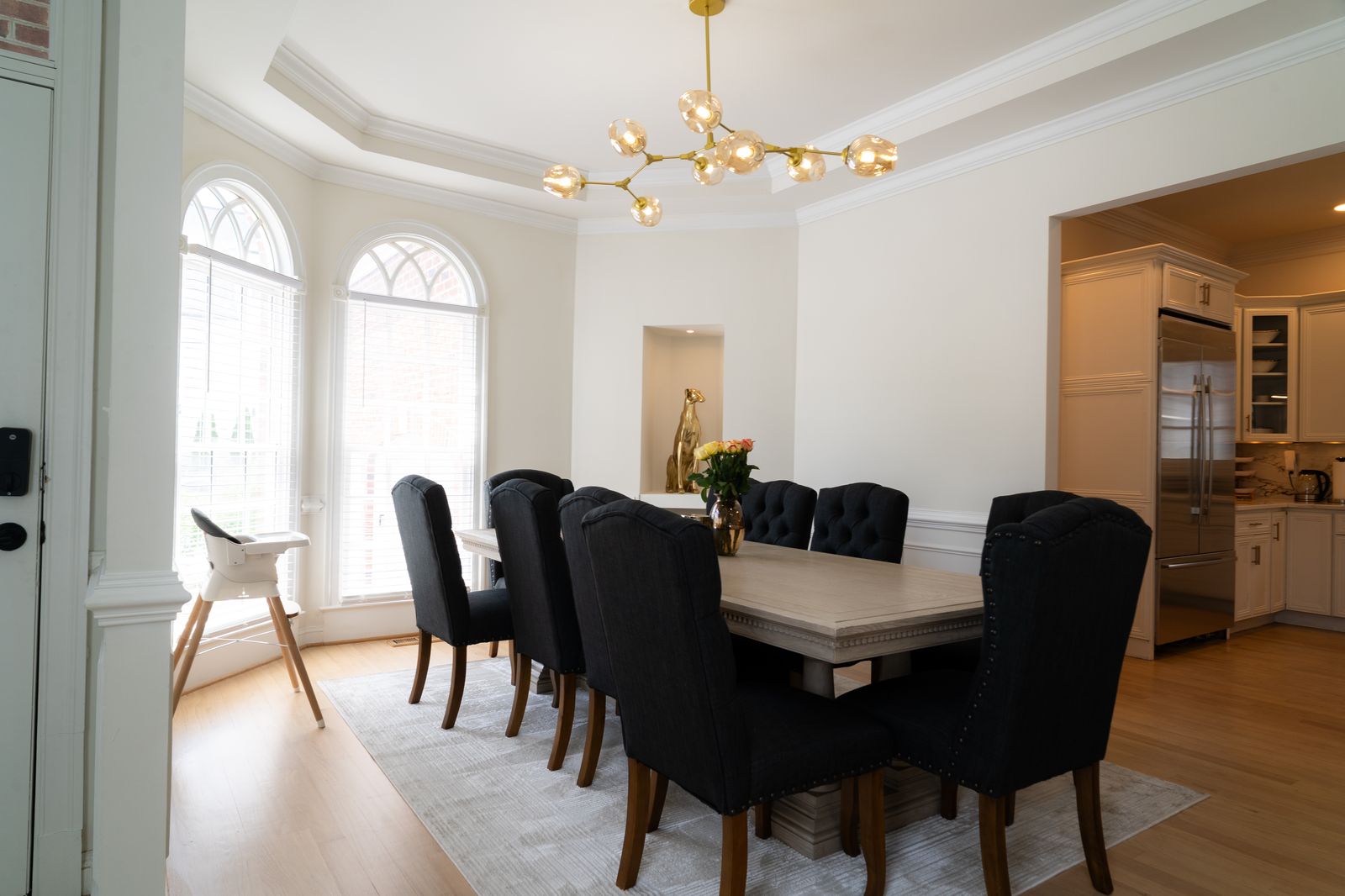 Dining room with arched windows and brass chandelier