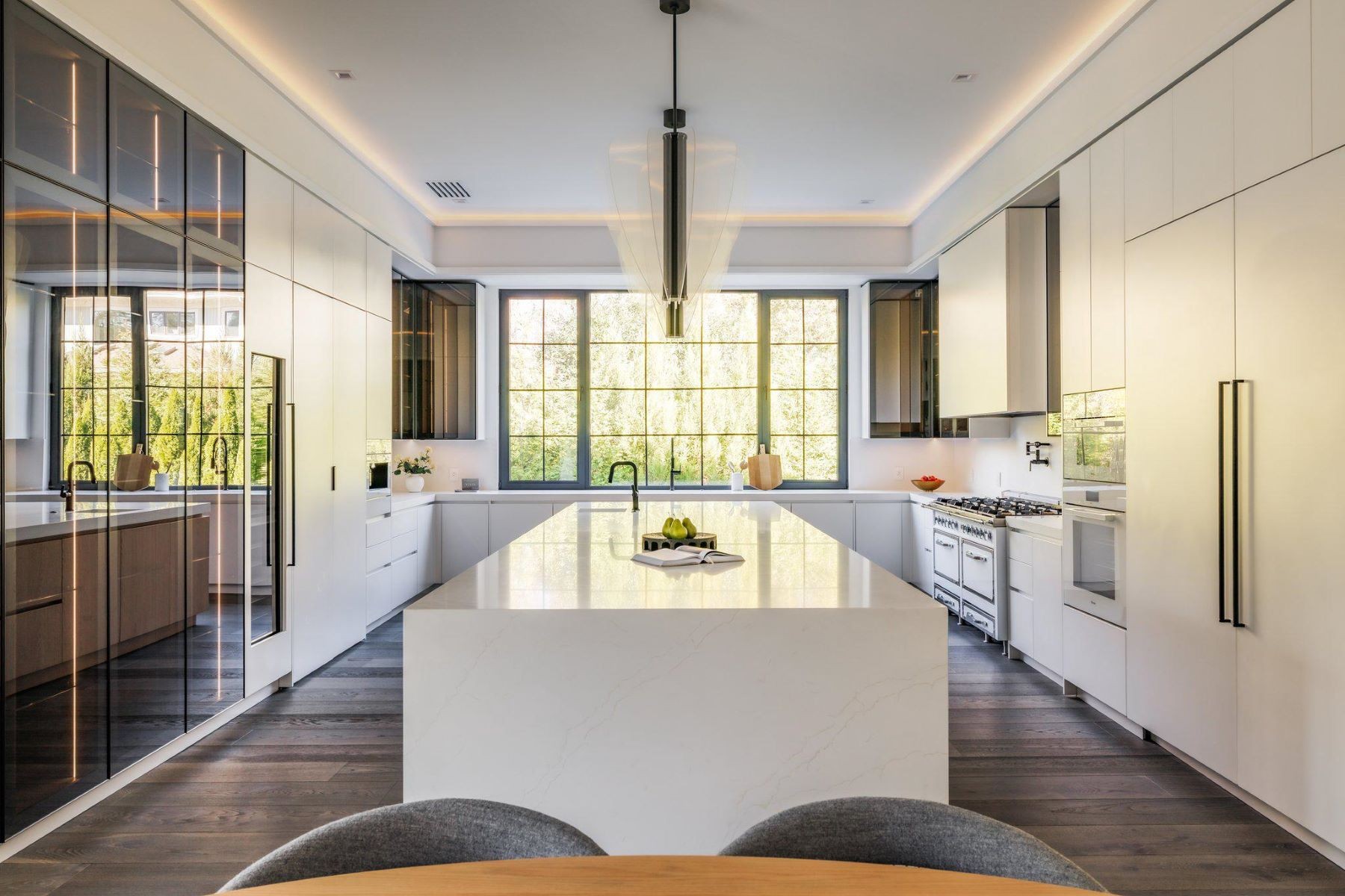 Chef’s kitchen with dual marble waterfall islands and full-height windows